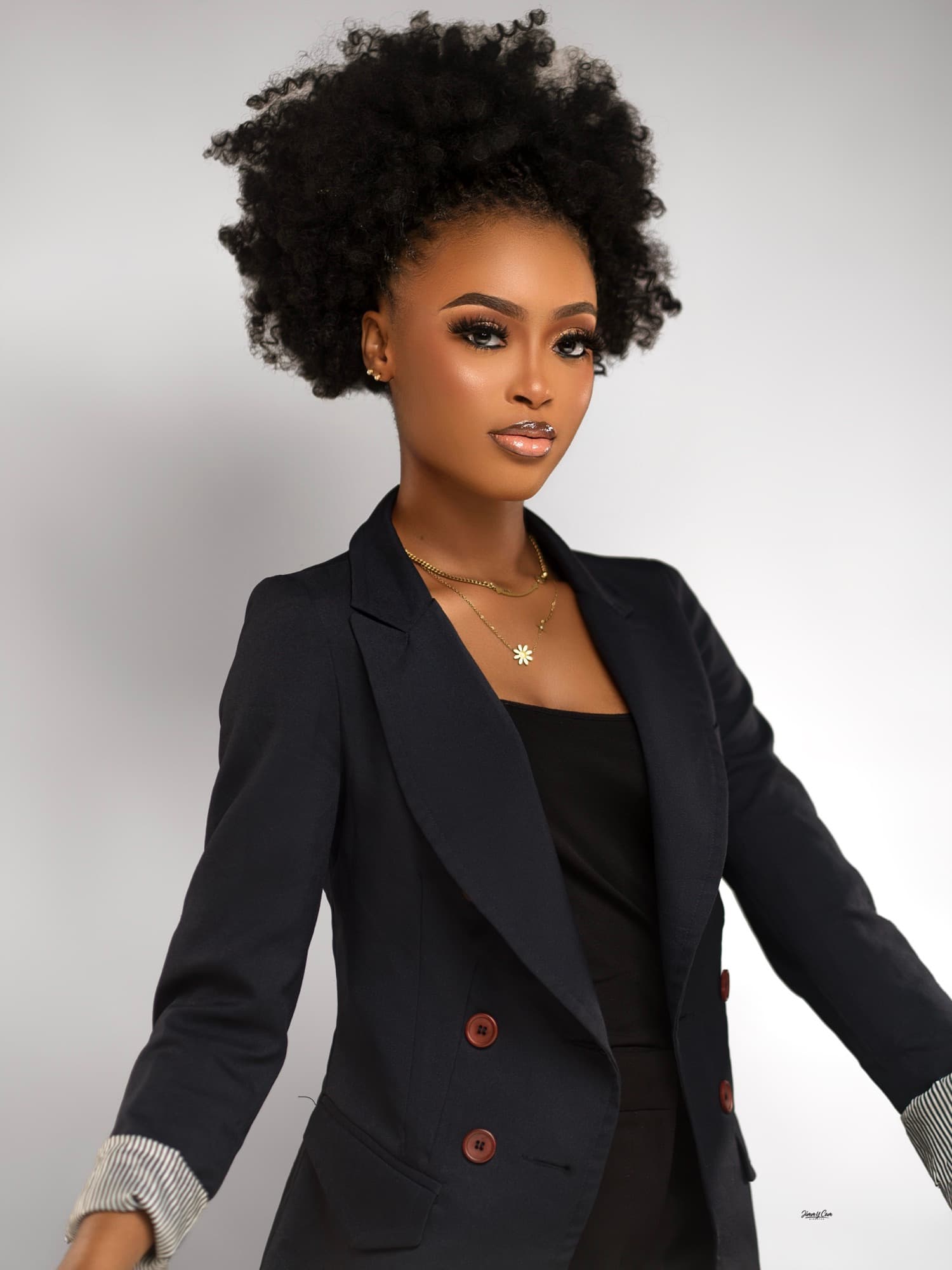 Portrait studio d'une jeune femme en blazer noir, fond clair